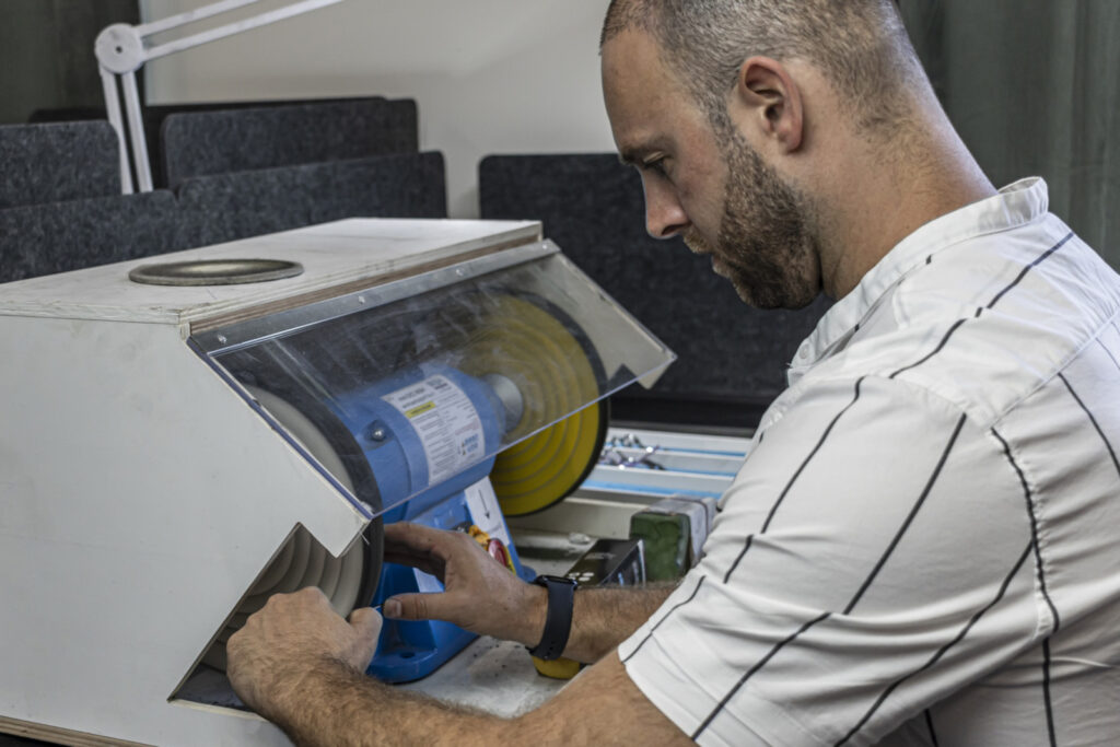 Kappersschaar wordt professioneel geslepen op de slijpmachine